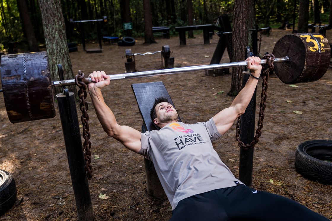 Man lifting a barbell outdoors