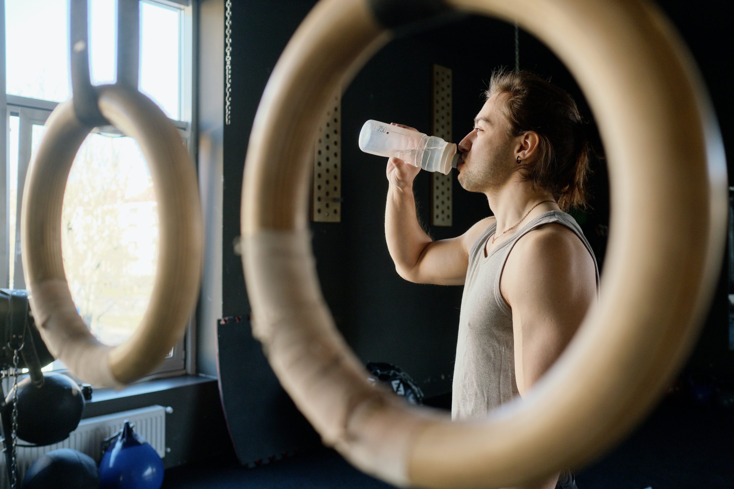 A man standing while drinking on a transparent tumbler